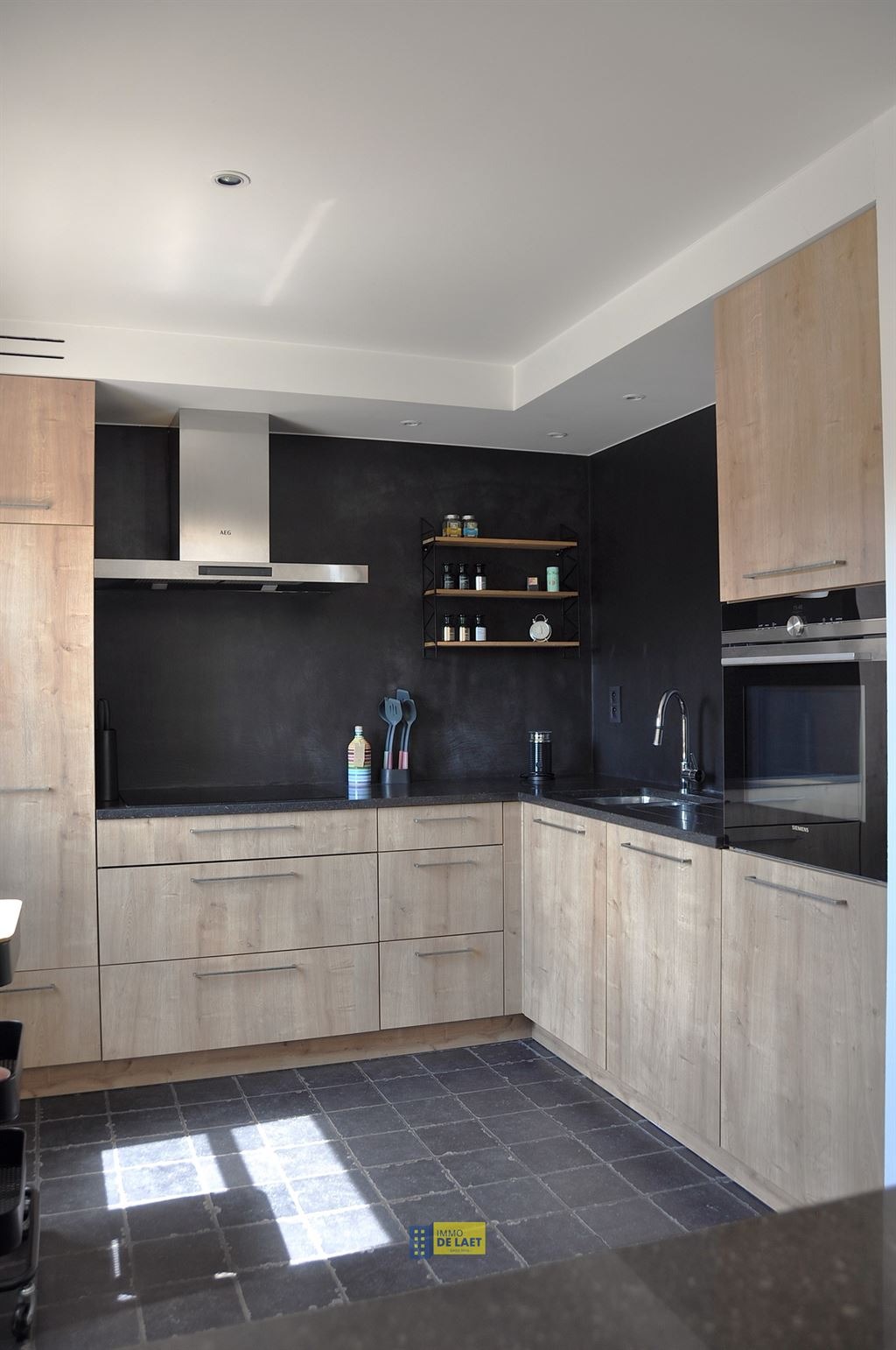 Keuken met houten fronten en zwarte achterwand